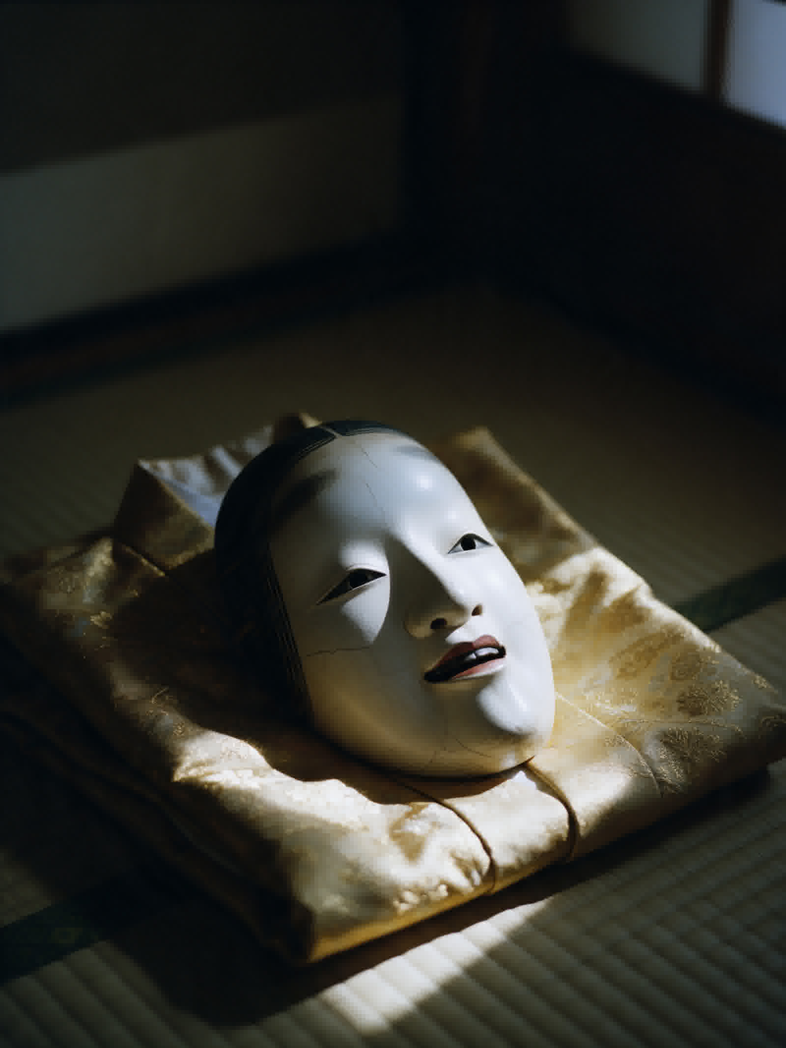 Noh mask in close view, carved wood in low light