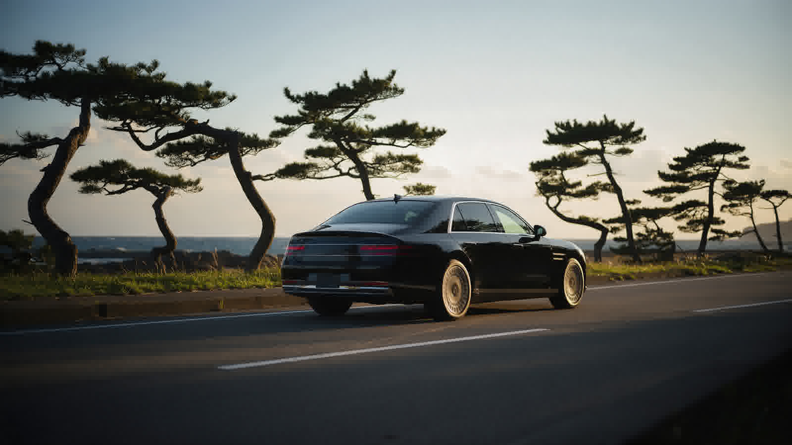 Private car on a coastal road, sea beyond