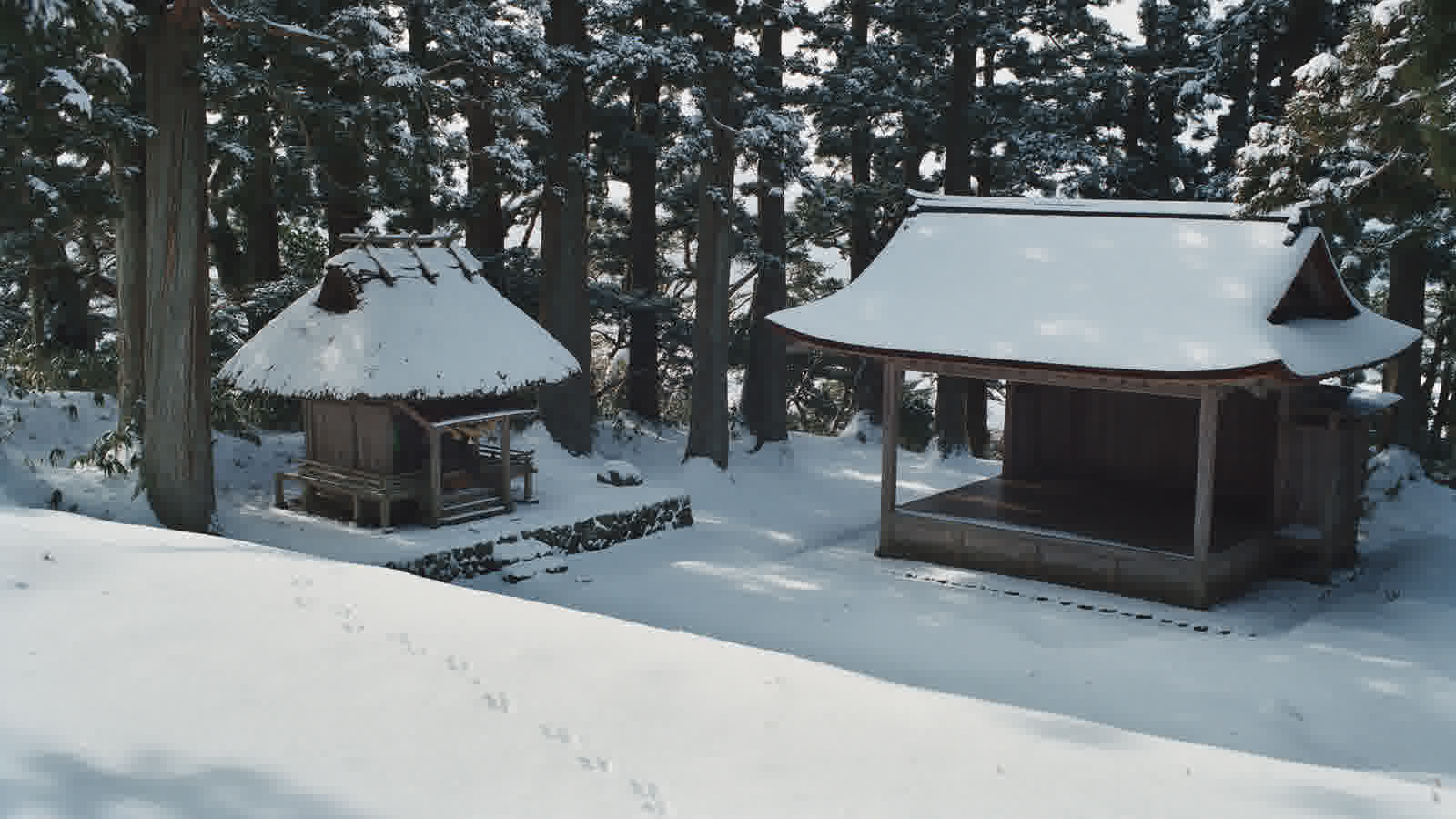 Thatched shrine under a light fall of snow