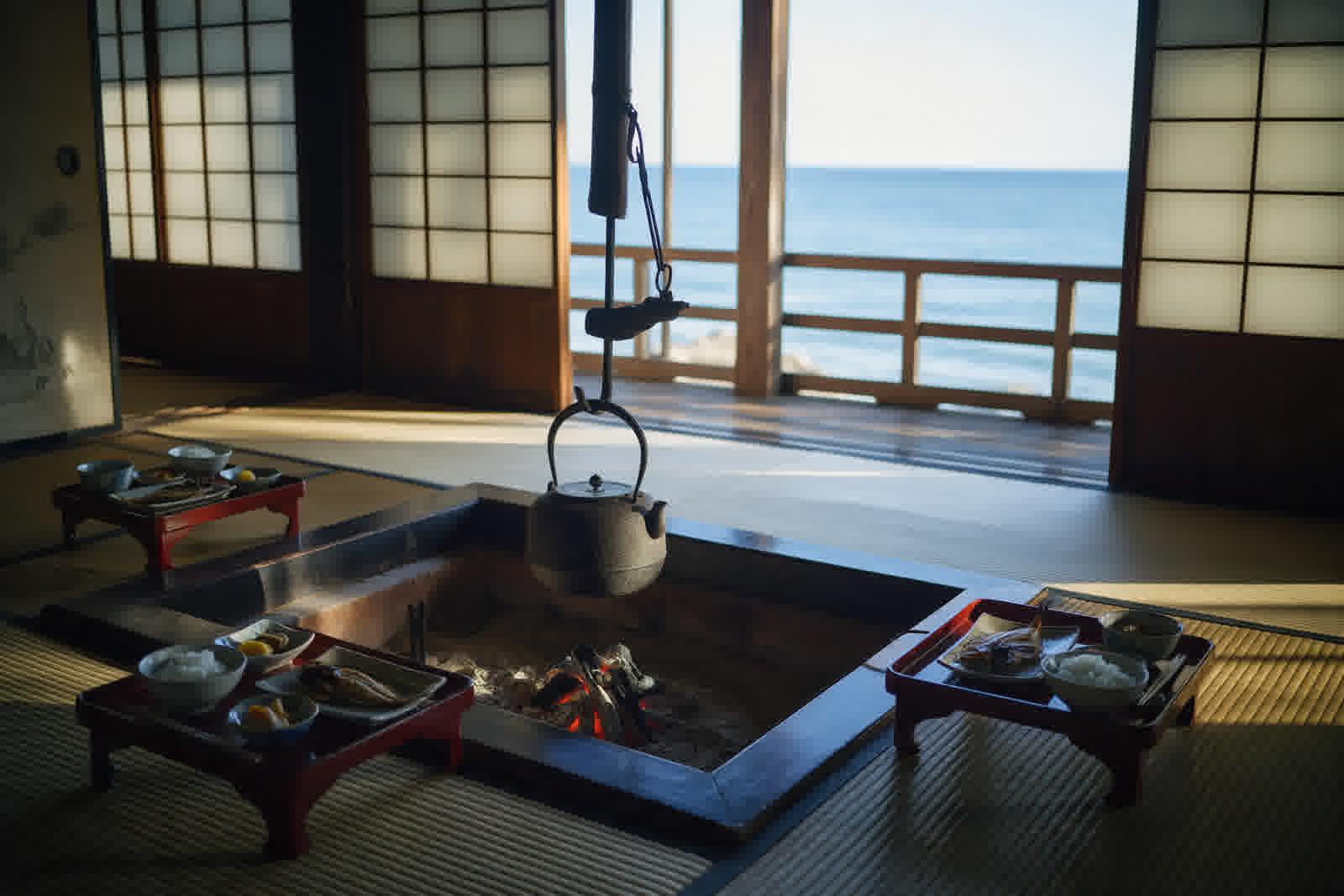 Sunken hearth at breakfast, lacquer trays and morning sea light